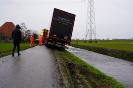 Vrachtwagen vast in berm door windvlaag in Starnmeer