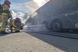 Lijnbus stopt na rook onder bus